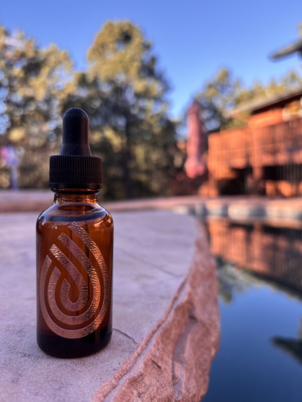 Radiance Face Serum bottle on the edge of a pool in natural light