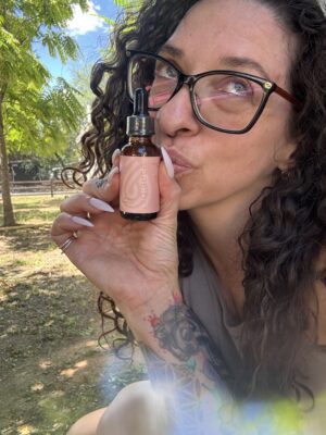 Chance holding and kissing a bottle of Source CBD Radiance Botanical Face Serum.